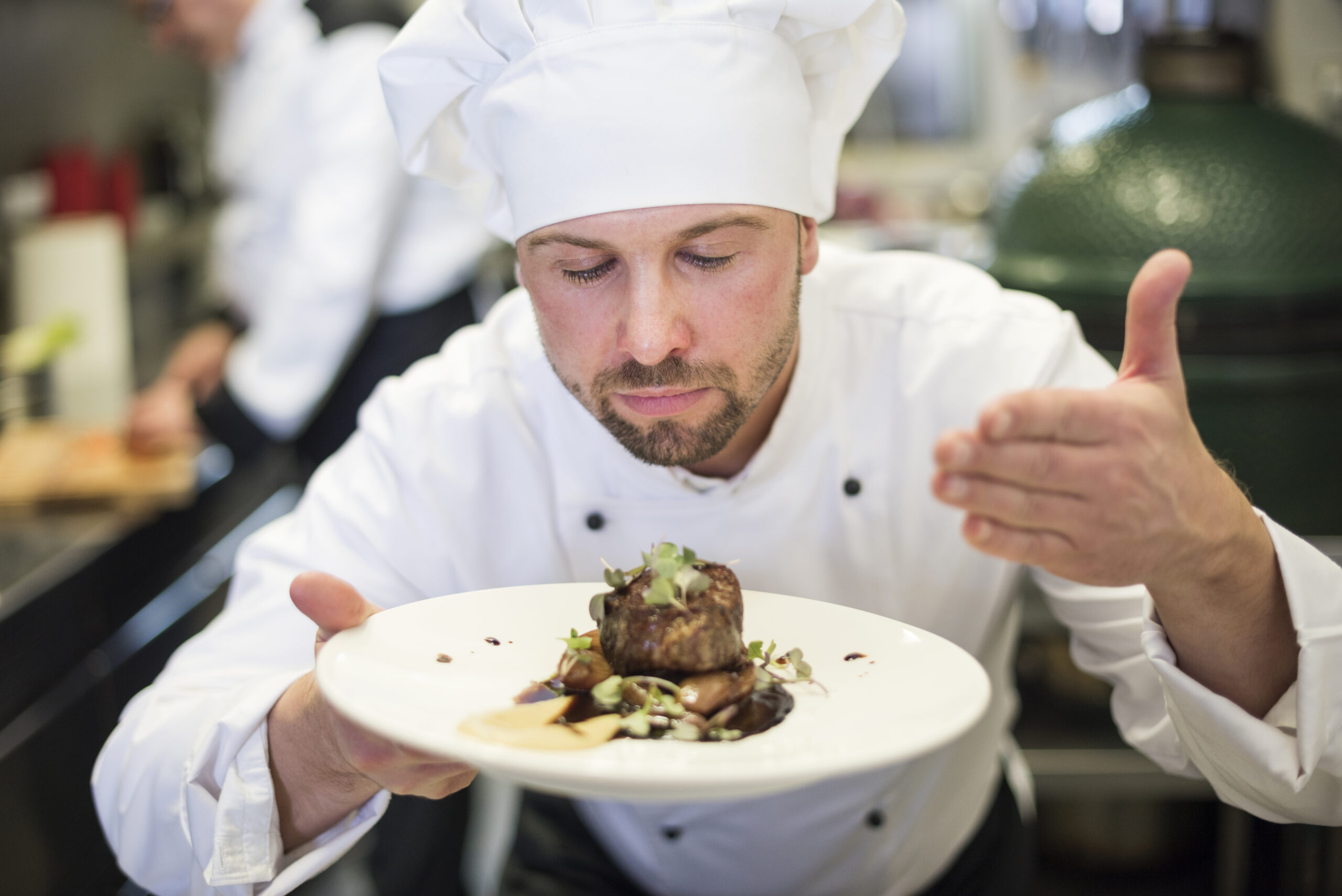 a chef smelling his dish after cooking, very proud of his work
